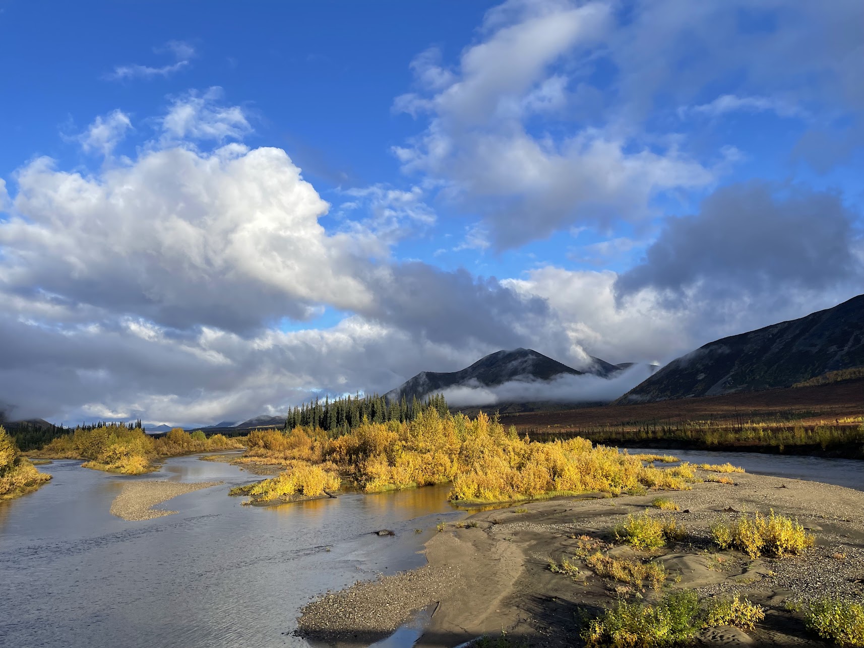 A river in Northern Alaska with fall colors and low clouds